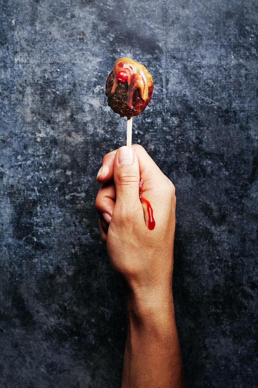 A meatball held like a lollipop A meatball held like a lollipop